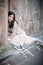 Young beautiful Indian Woman sitting against stone wall outdoors