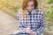 Young beautiful inspired girl in checkered shirt with headphones writing in her notebook. College university campus student teen t