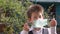 Young beautiful kid in white shirt and gray vest takes off medical protective mask, breathes wonderful morning air and smile