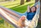 young beautiful lady posing while lying on hammock,