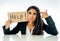 Young beautiful latin business woman overwhelmed and tired holding a help sign. looking Stressed, bored, frustrated, upset and