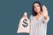 Young beautiful latin woman holding money bag with dollar symbol with open hand doing stop sign with serious and confident