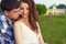 Young beautiful loving happy couple sitting in the box on the grass in the warm evening summer day