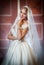 Young beautiful luxurious woman in wedding dress posing in luxurious interior. Gorgeous elegant bride with long veil. Full length