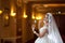 Young beautiful luxurious woman in wedding dress posing in luxurious interior. Gorgeous elegant bride with long veil. Seductive