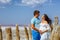 Young beautiful married couple, pregnant woman in white dress in nature, happy parents waiting for baby