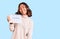 Young beautiful mixed race woman holding travel calendar looking positive and happy standing and smiling with a confident smile