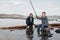 Young, beautiful mother and son have fun fishing on the lake