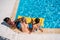 Young beautiful multiethnic women sitting near swimming pool