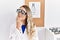Young beautiful optician woman wearing optometry glasses at the clinic serious face thinking about question with hand on chin,