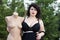 Young beautiful plus size modelt in black bra holding mannequin