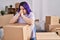 Young beautiful plus size woman stressed leaning on package at new home