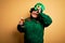 Young beautiful plus size woman wearing green hat celebrating st patricks day drinking beer with happy face smiling doing ok sign