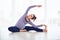 Young beautiful pregnant woman doing yoga asana Parivrtta Janu Sirsasana at home.