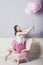 Young beautiful pregnant woman with pink balloons and a pink ballet skirt