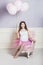 Young beautiful pregnant woman with pink balloons and a pink ballet skirt