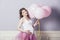Young beautiful pregnant woman with pink balloons and a pink ballet skirt