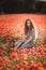 Young beautiful red-hear girl in red poppy field