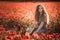 Young beautiful red-hear girl in red poppy field