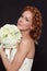 Young beautiful redhead bride with prom hairdo and bouckuet