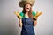 Young beautiful redhead farmer woman wearing apron and hat over white background celebrating mad and crazy for success with arms