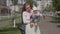 Young beautiful redhead mother holding a cute baby boy in her arms and talking to him in a spring sunny day. Mom with a