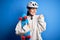 Young beautiful redhead skateboarder woman wearing safety helmet holding skate pointing and showing with thumb up to the side with