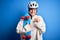 Young beautiful redhead skateboarder woman wearing safety helmet holding skate with surprise face pointing finger to himself