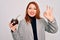 Young beautiful redhead woman drinking argentina mate beverage over white background doing ok sign with fingers, excellent symbol