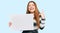 Young beautiful redhead woman holding blank empty banner surprised with an idea or question pointing finger with happy face,