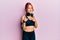 Young beautiful redhead woman wearing gym clothes and using headphones pointing fingers to camera with happy and funny face