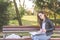 Young beautiful school or college girl with eyeglasses sitting on the bench in the park reading the books and study for exam