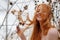 Young beautiful sexy redhead woman plays laughing with pine cones and her beautiful red hair caught in a pine branch