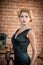 Young beautiful short hair blonde woman in black dress posing . Elegant romantic mysterious lady with movie star look