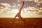 Young beautiful slim woman silhouette practices yoga on the beach at sunset. Yoga at sunrise