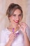 Young beautiful smiling woman holding a menstruation cotton tampon in one hand and with her other hand a plastic purple