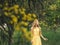 Young beautiful smiling woman in spring Australian Golden wattle trees.