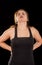 Young beautiful sportwoman suffer cervical pain in her lower back, in black background