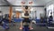Young beautiful sporty girl doing shoulder press with dumbbells exercising while sitting on sports bench in a sport gym