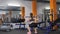 Young beautiful sporty girl squatting with a bar in a sport gym, back side view 60 fps