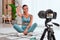 Young beautiful sporty woman vlogger is making video training for blog exercising in front of a home camera