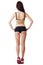 Young beautiful sporty woman wearing sports shorts and top stands with his back