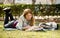 Young beautiful student girl on campus park grass with books studying happy preparing exam in education concept