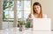 Young beautiful student woman with laptop at table, at home