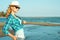 Young beautiful stylish blond lady in mirrored sunglasses and straw panama at the seaside