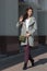 young beautiful stylish woman in burgundy coats, street style, spring and autumn trend, dark skirt, beige sweater, flirty look, ha