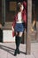 young beautiful stylish woman in claret coat, street style, spring summer trend, dark skirt, beige sweater, flirty