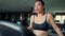 Young beautiful sweaty and tired Asian korean runner woman cooling off walking and breathing in gym treadmill after jogging