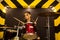 Young beautiful tattooed girl in a leather jacket plays drums in a recording Studio on the bright black and yellow band