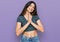 Young beautiful teen girl wearing casual crop top t shirt praying with hands together asking for forgiveness smiling confident